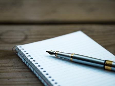 Close-up of a pen on a handwritten document, representing the risks of a holographic will