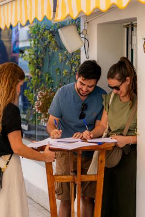 Two witnesses watching someone sign a will in Canada at a home table