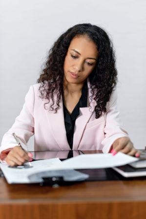 Person signing a legal will document in British Columbia at a desk