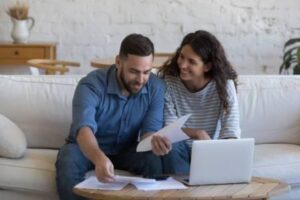 Couple reviewing will kit options together at home on a laptop in Canada