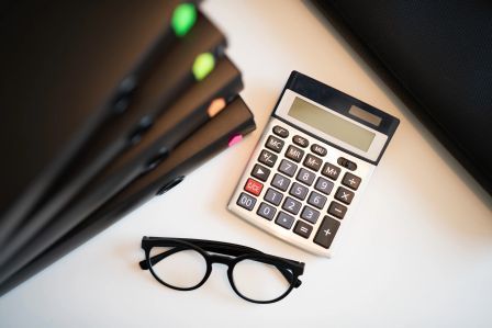 Calculator and financial documents representing Ontario Estate Administration Tax calculation