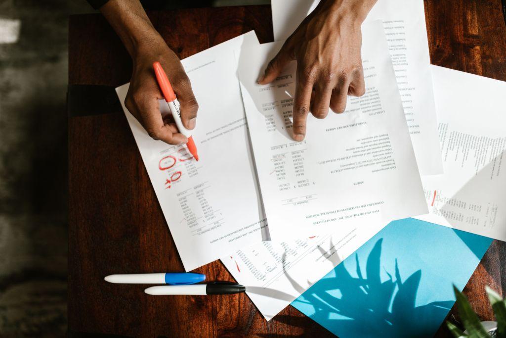 Canadian adult working through a will checklist with pen and notebook at a desk